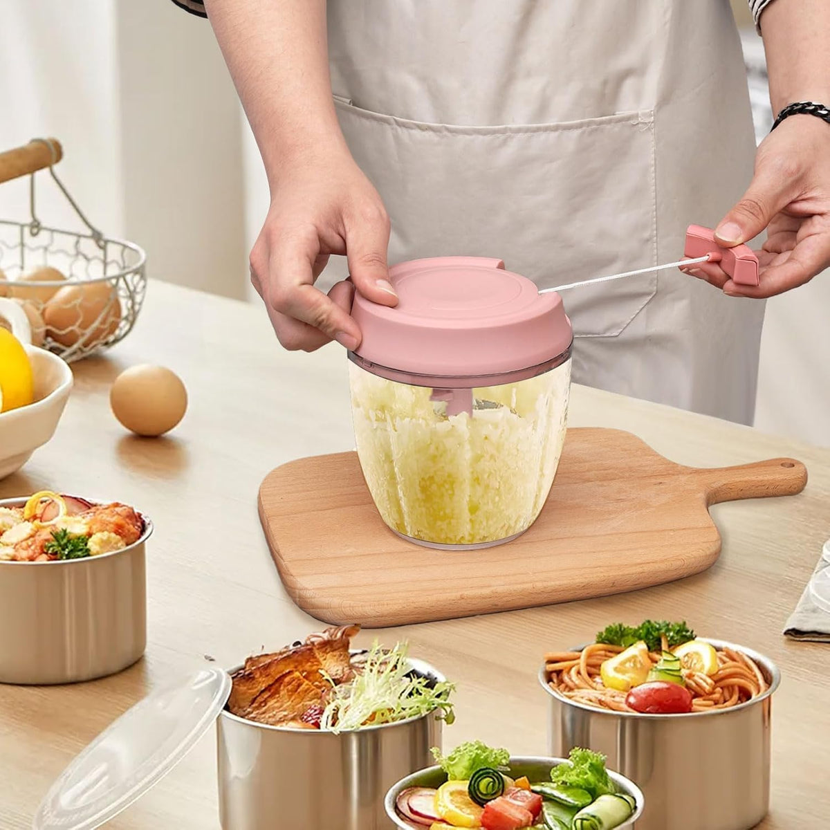 A Person is Using Manual Food Processor to Chop Food Items.