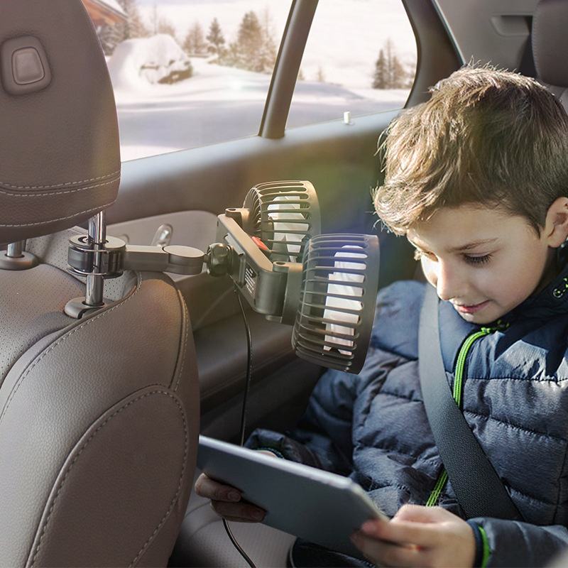 A Child is Sitting Inside a Car where Rotating Mini Car Vehicle Cooling Double Headed Clip Lock Fan is Fixed on the Car Headrest.