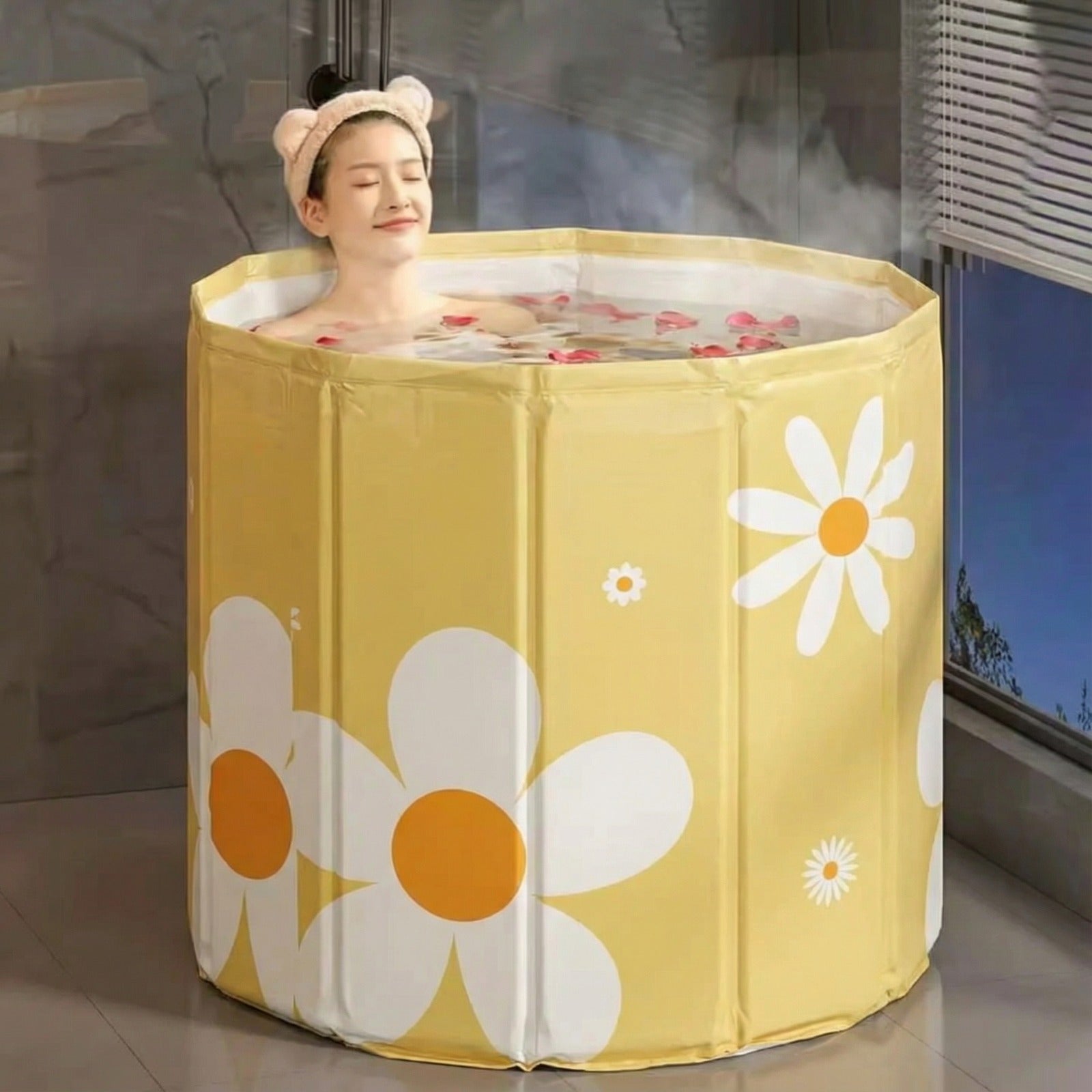 A woman is relaxing in a portable adult bathtub.
