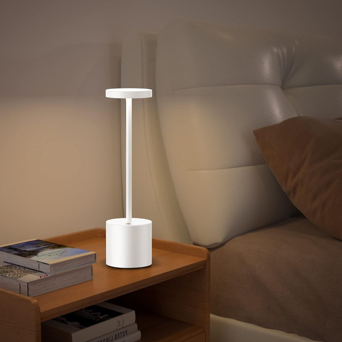 White lamp on a wooden nightstand next to a bed