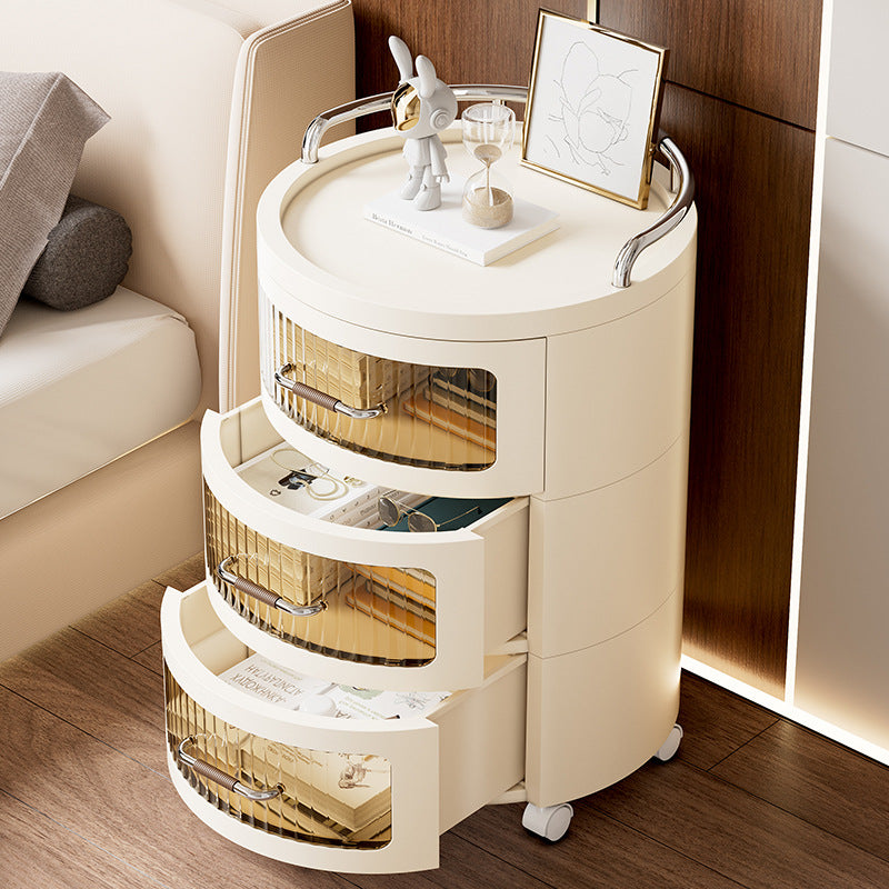 Round Rolling Storage Cabinet with Books are Organized in it.