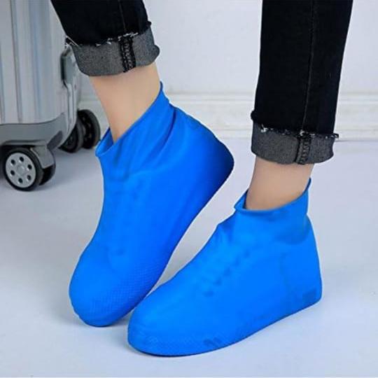 A Person is Protected his Shoe by Wearing Silicone Waterproof Shoe Cover in Blue Color.