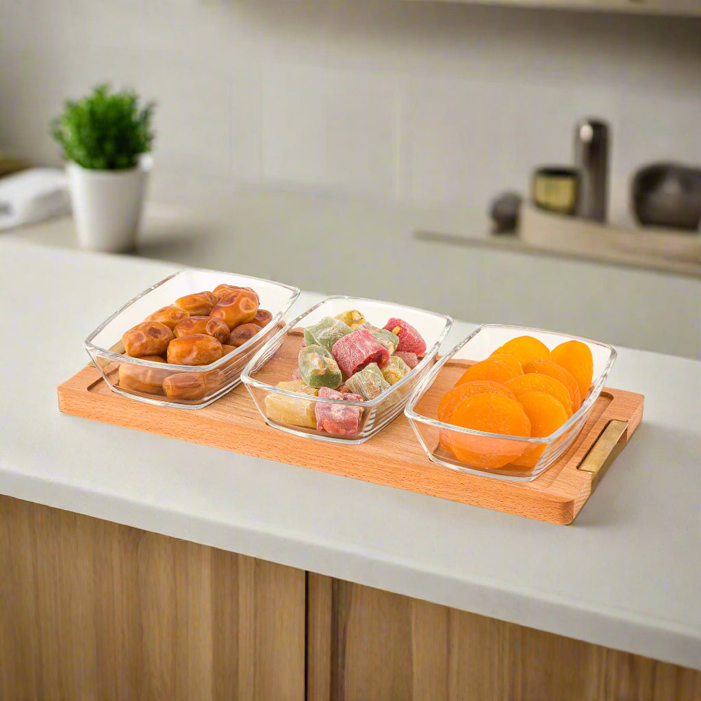 A Snack Serving 3-Section Glass Bowl with Wooden Base Tray with Dried Fruits.