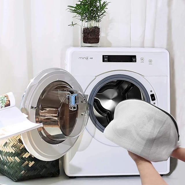 A person preparing to wash shoes using the Reusable Shoes Sneakers Washing Mesh Laundry Bag with Zip Closure