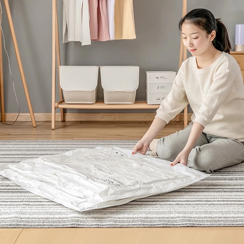 A Women is Arranging Clothes in a Space Saving Vacuum Seal Bags.