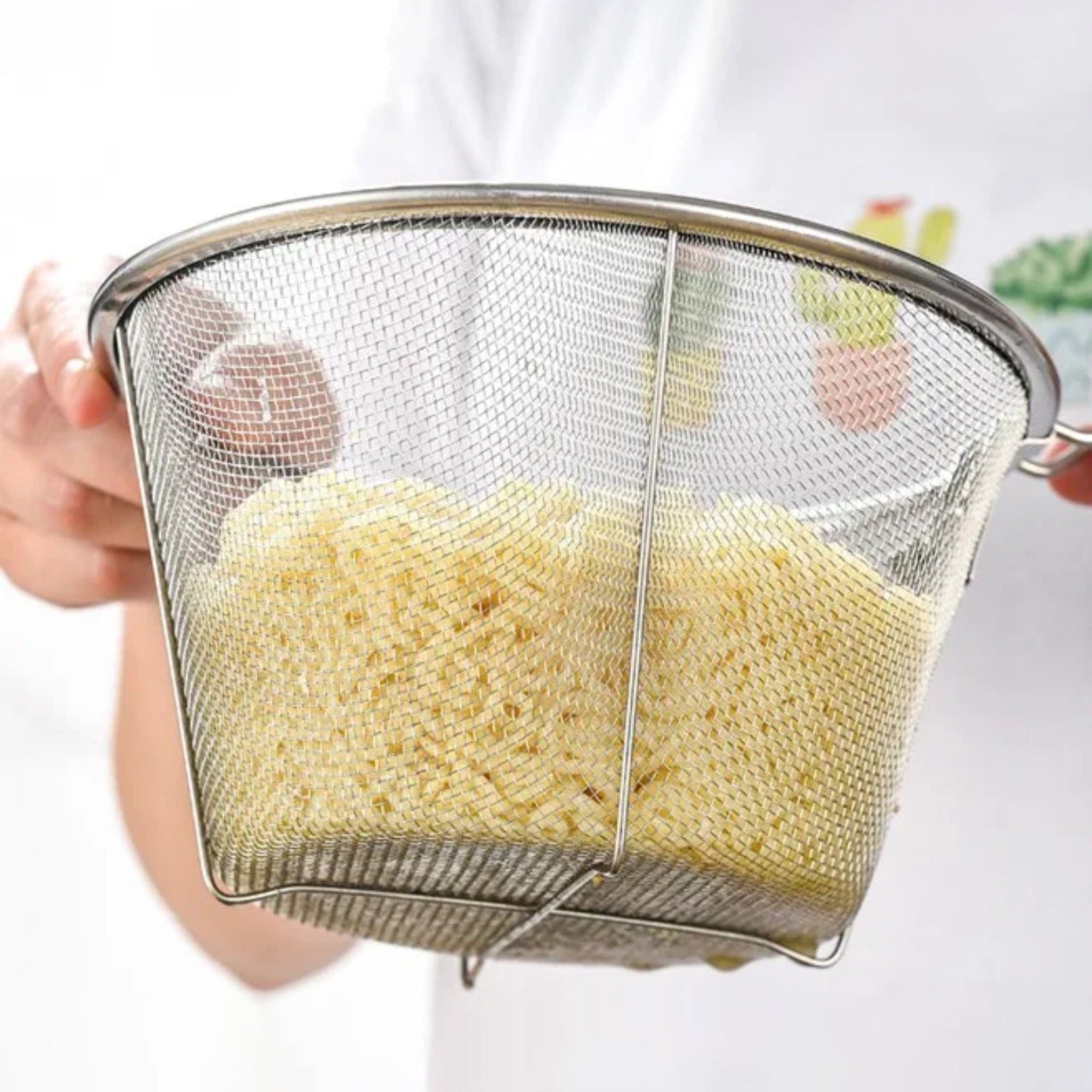 A person using a Deep Fry basket holding cooked noodles; easy to lift and Draining