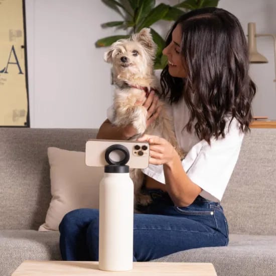 A Women is Placed Her Mobile Phone On Stainless Steel Vacuum Water Bottle With MagSafe Magnetic Phone Holder.