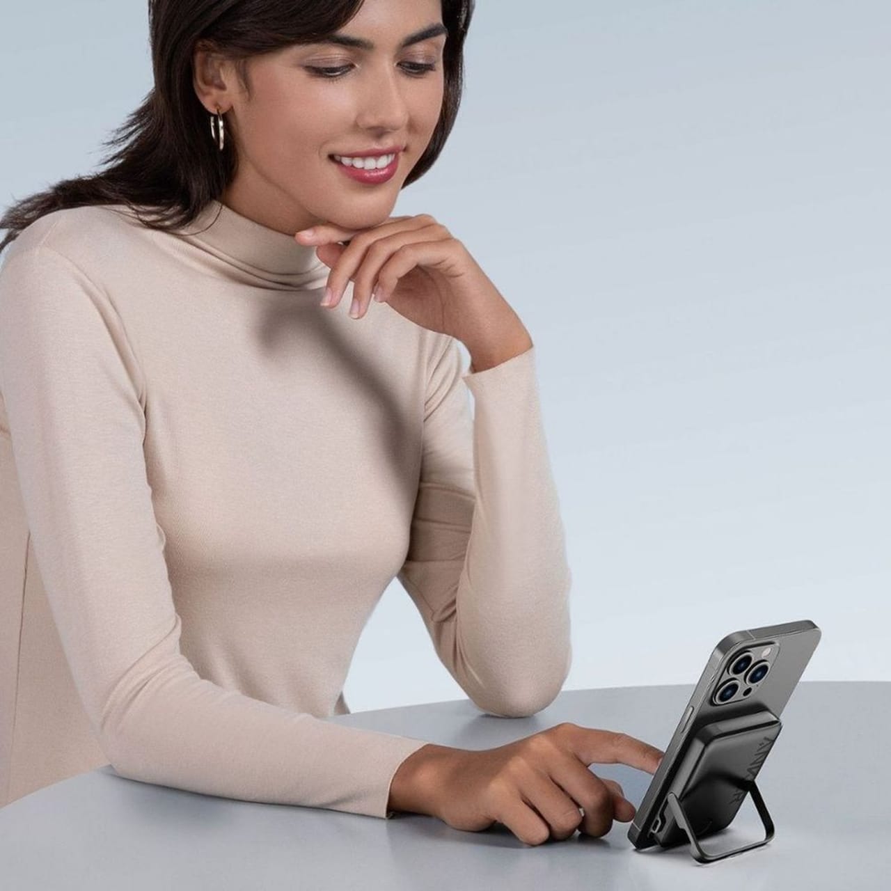 A Women Keeping Her Mobile Phone on ANKER MagGO Power Bank Stand.