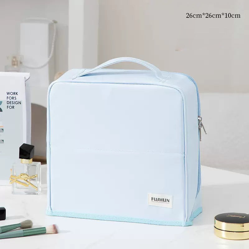 Travel Makeup Bag Cosmetic Organizer Case with a top handle, shown on a white tabletop with a perfume bottle, makeup brushes, and compact powder nearby. The bag has a small white label reading FUJABIN and a size text overlay in the top right corner.