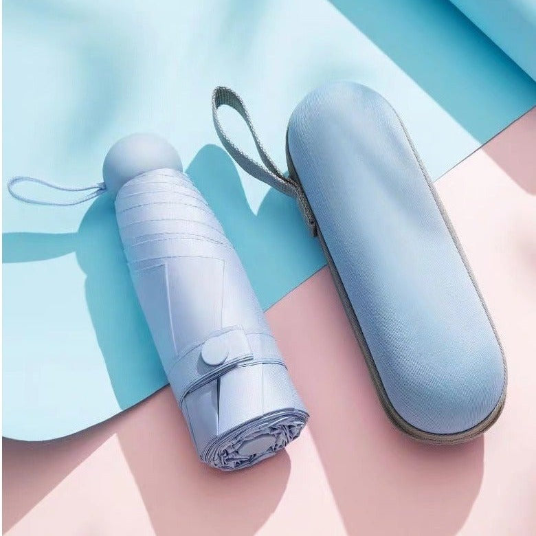 Travel Mini Folding Pocket Umbrella with carrying case on a light blue and pink background