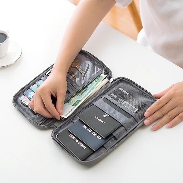 Someone packing their documents into the Travel Passport and Document Organizer Bag