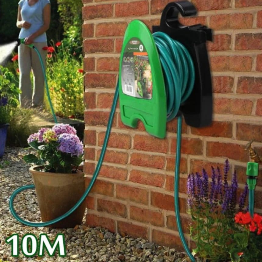 A Woman is Watering Plants Using Garden Hose Reel Pipe.