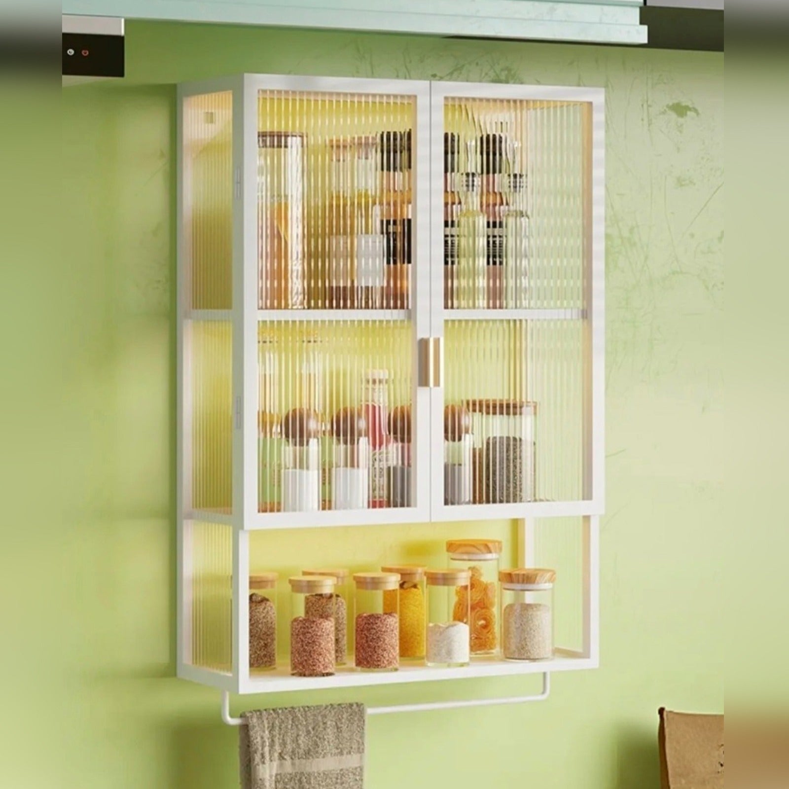 Wall-mounted storage organizer with ribbed glass doors, displaying neatly arranged spice bottles.