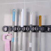 Mops and Brooms are Organized in a Wall Mounted Mop Holder.
