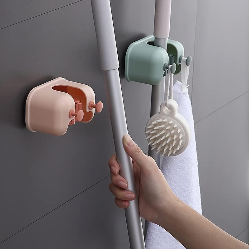 A Person is Keeping a Mop On Wall Mounted Single Mop Holder.