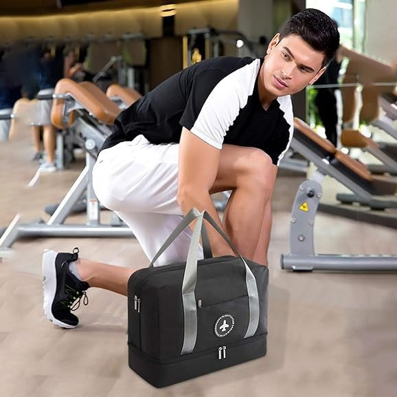 man lacing his shoe in gym while his gym bag is lying down on the floor