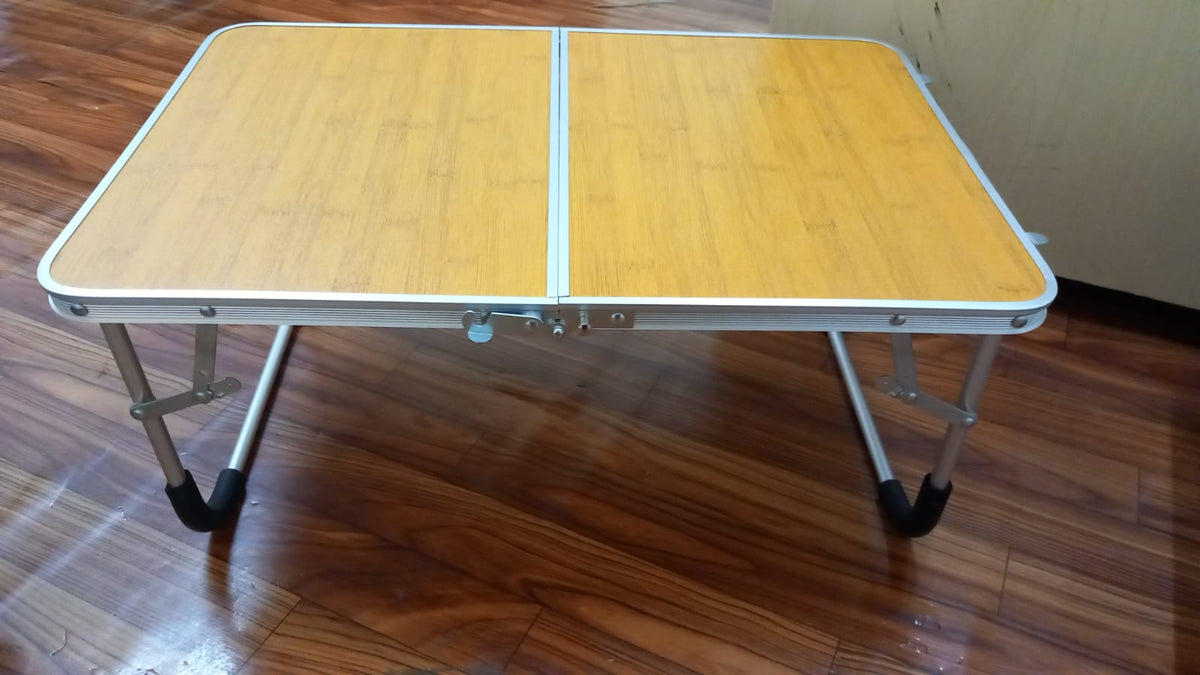 The portable folding mini table is placed on the floor