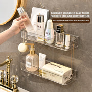 A transparent plastic shelf designed for bathroom storage, featuring a gold necklace and perfume bottle, perfect for organizing toiletries and cosmetics