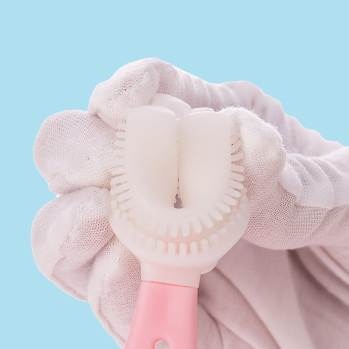 A person holding a U-shaped kids toothbrush on it's head