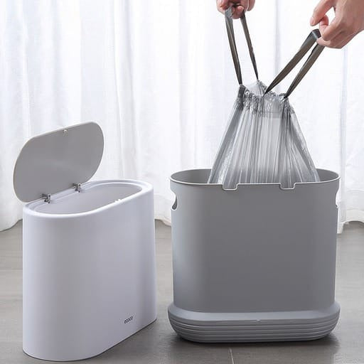 A person lifting Drawstring Garbage Bag from a trash can