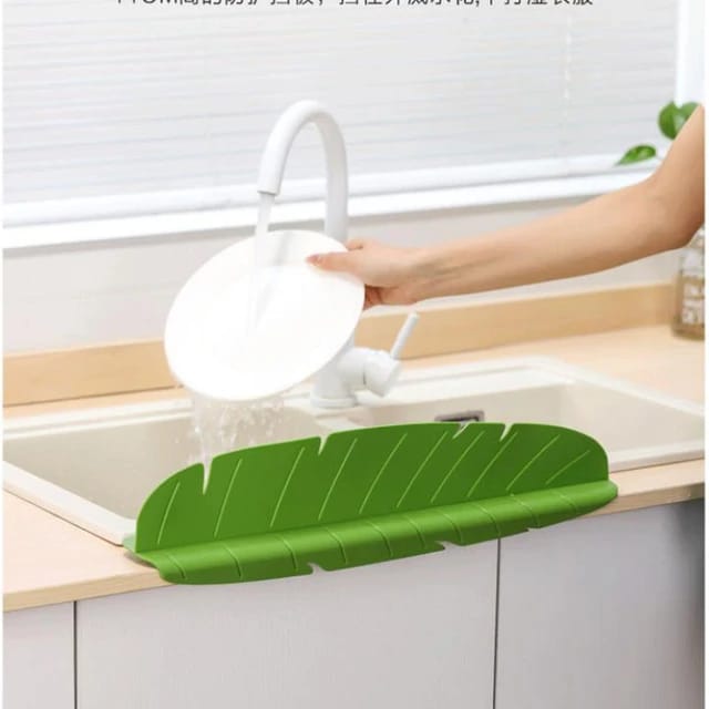 Kitchen Sink Splash Guard installed on a sink in which a person is washing plate
