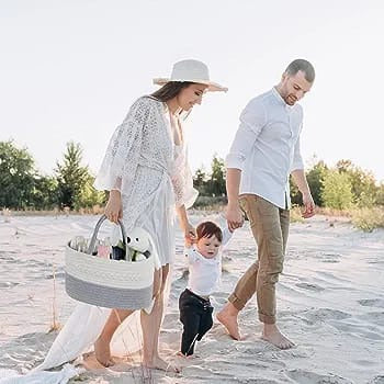 A woman carrying Nursery Storage Basket and walking with a baby and a man on a beach