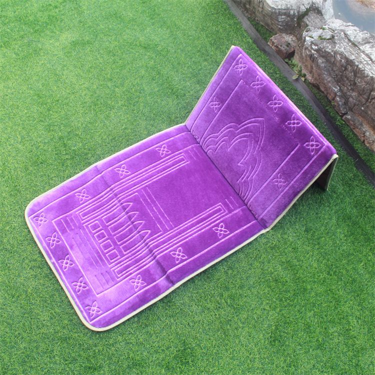 Purple color Islamic Foldable Prayer Mat placed on a grass with backrest opened