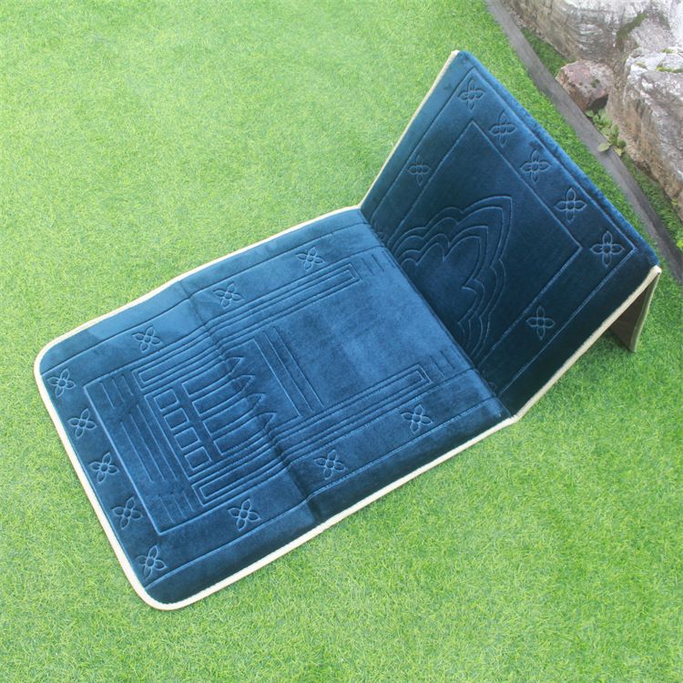 Blue color Islamic Foldable Prayer Mat placed on a grass with backrest opened