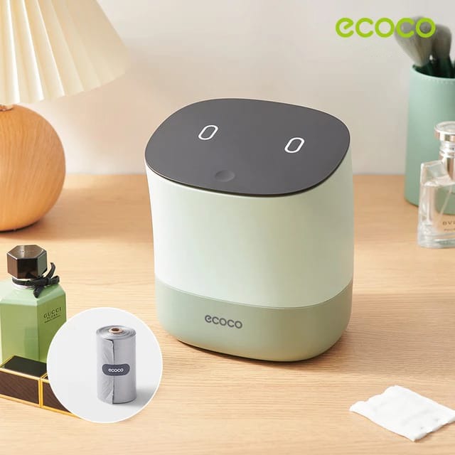 Showcasing Green color Mini Desktop Waste Bin placed next to a night lamp and a perfume on a table  