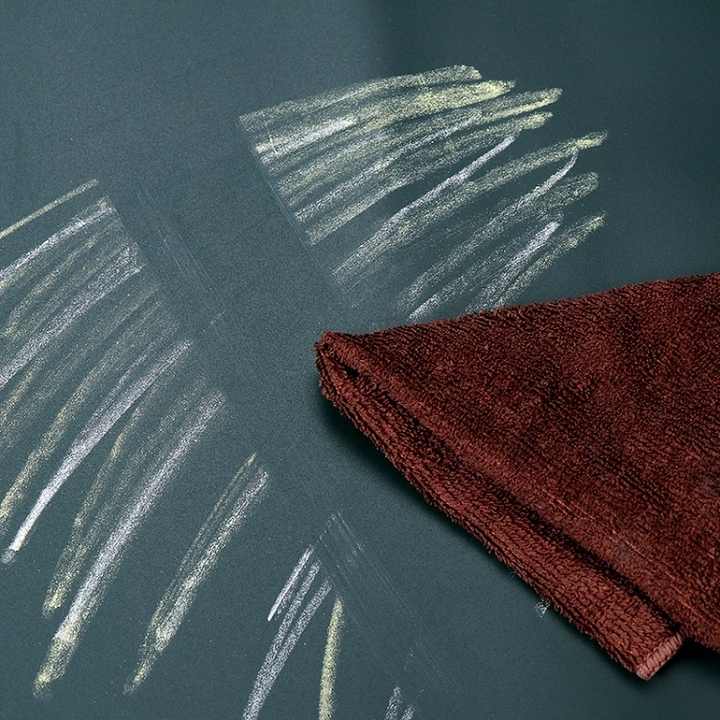 Chalk shades being rubbed off from a Chalkboard Wall Sticker with the help of towel 