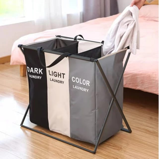 A person putting a laundry cloth into a 3 Sections Laundry Basket placed in a bedroom 