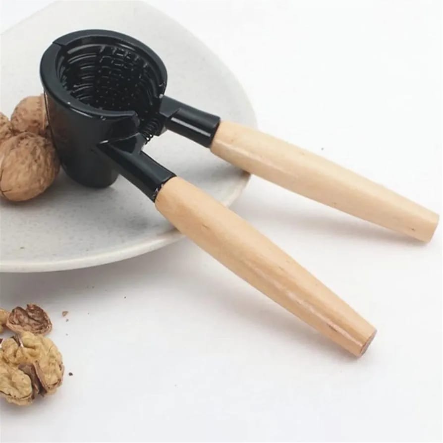 Nutcracker Tool kept on a plate with cracked nuts 
