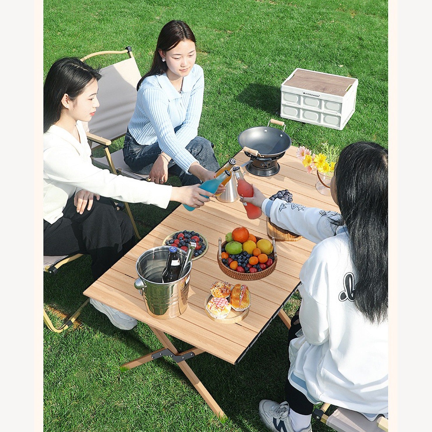 Three girls chilling on Portable Folding Chairs and Table, surrounded by fresh fruits and burgers.
