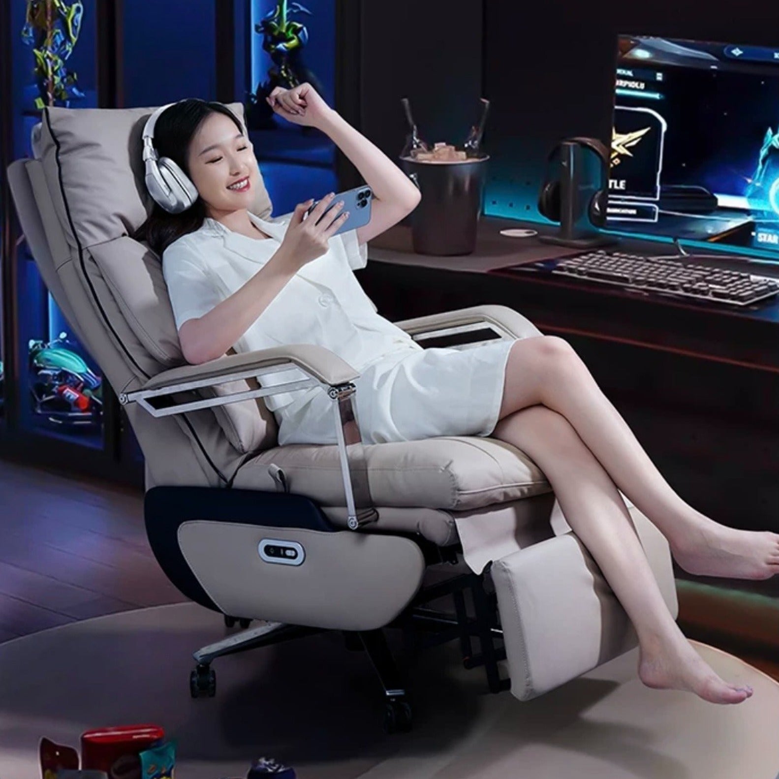 A person relaxing on an Adjustable Electric Office Chair situated beside to a PC and watching mobile 