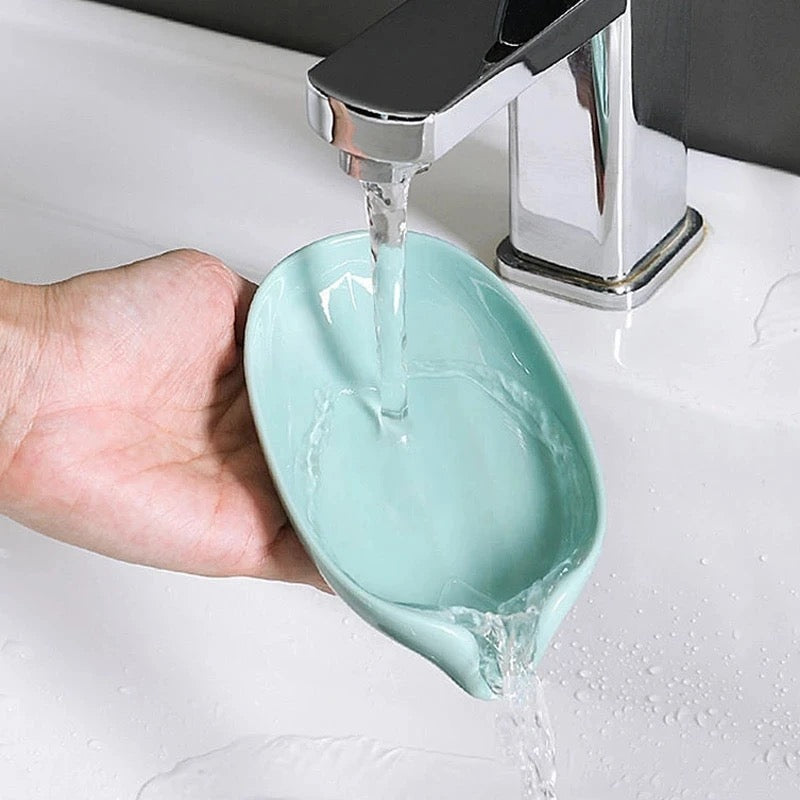 Leaf Shaped Soap Holder being washed by a person and it drains the water through its drainage head