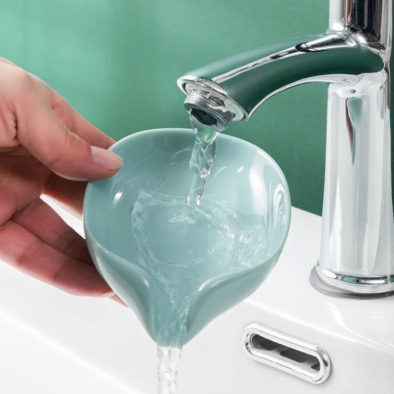 Leaf Shaped Soap Holder being washed by a person and it drains the water through its drainage head 