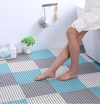 A person standing in a bathroom floored with Interlocking Non-Slip Bathroom Mat