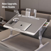 Laptop, headset, and book neatly arranged on the Adjustable Bed Laptop Table – a Foldable Lifting Desk for a versatile and comfortable workspace
