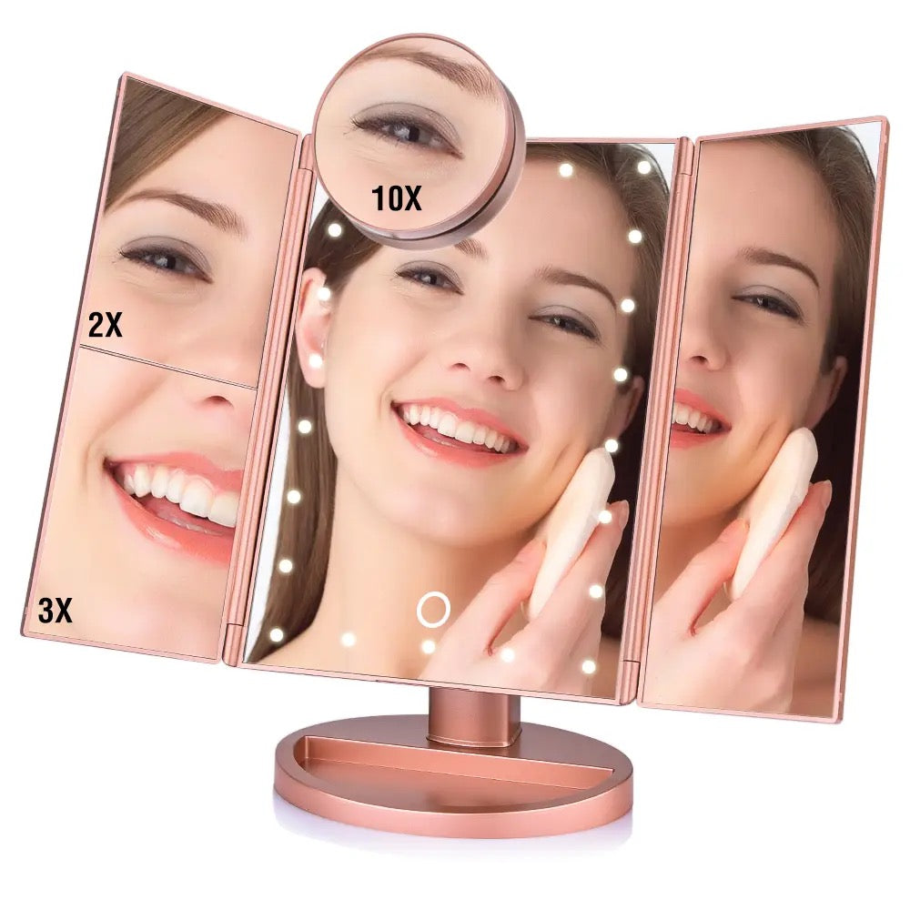 A woman gazes into a tri-fold makeup mirror with LED lights