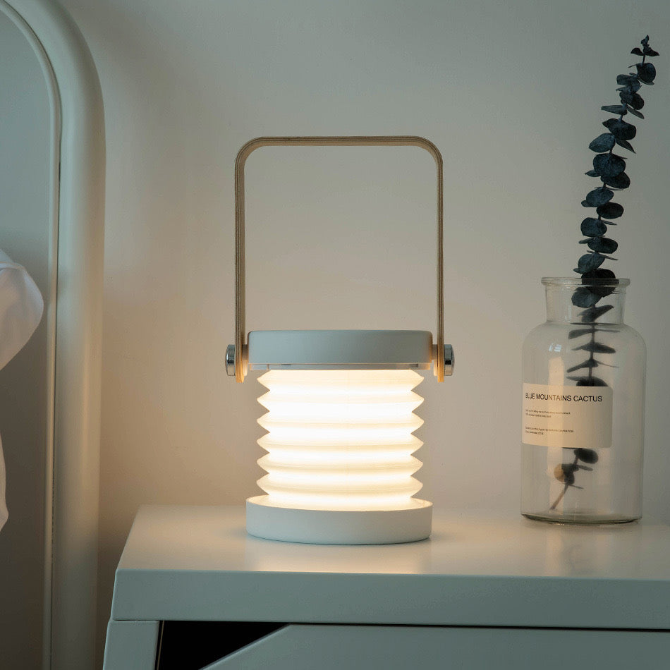 Retractable Table Lamp with USB Rechargeable, placed on a table next to a vase