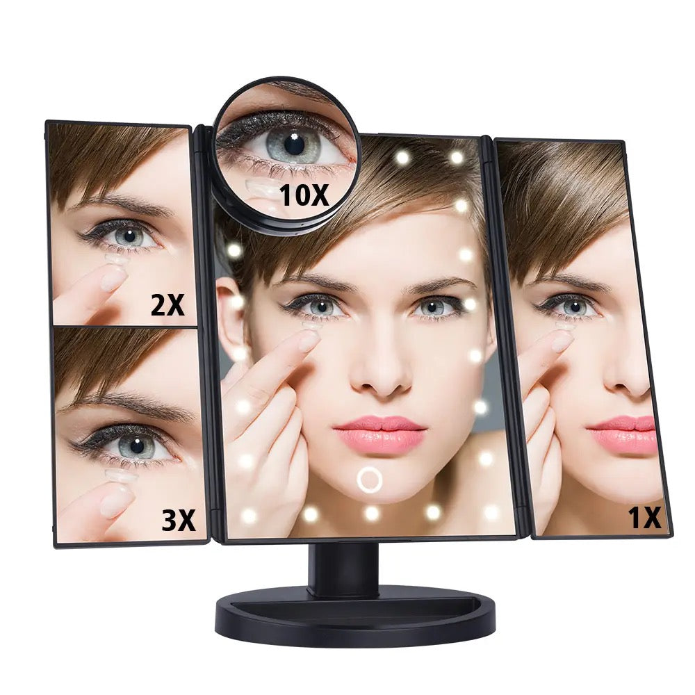A woman gazes into a tri-fold makeup mirror with LED lights