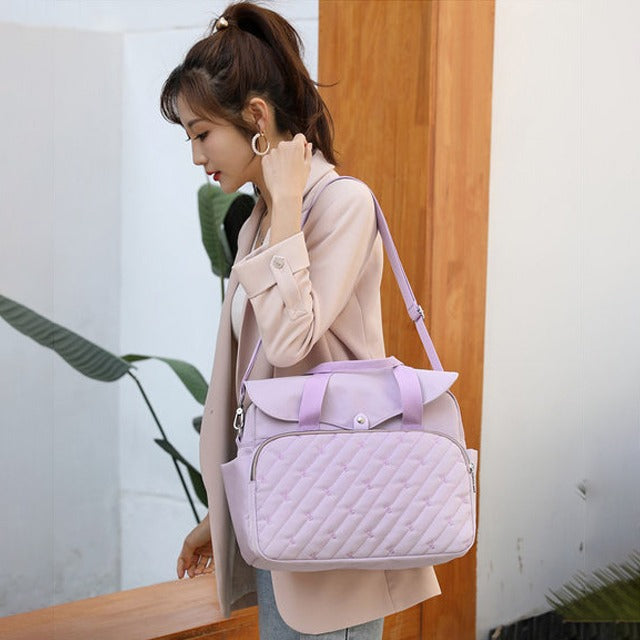 A Women is Carrying Fashionable Baby Diaper Bag.