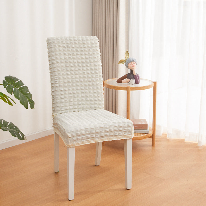 A Chair is Covered With White Bubble Stuff Stretchable Chair Cover.