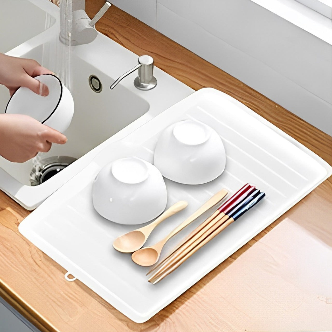 A Person is Cleaning Bowls And Utensils Are Placed On The Sink Dish Drainer Tray Rack.