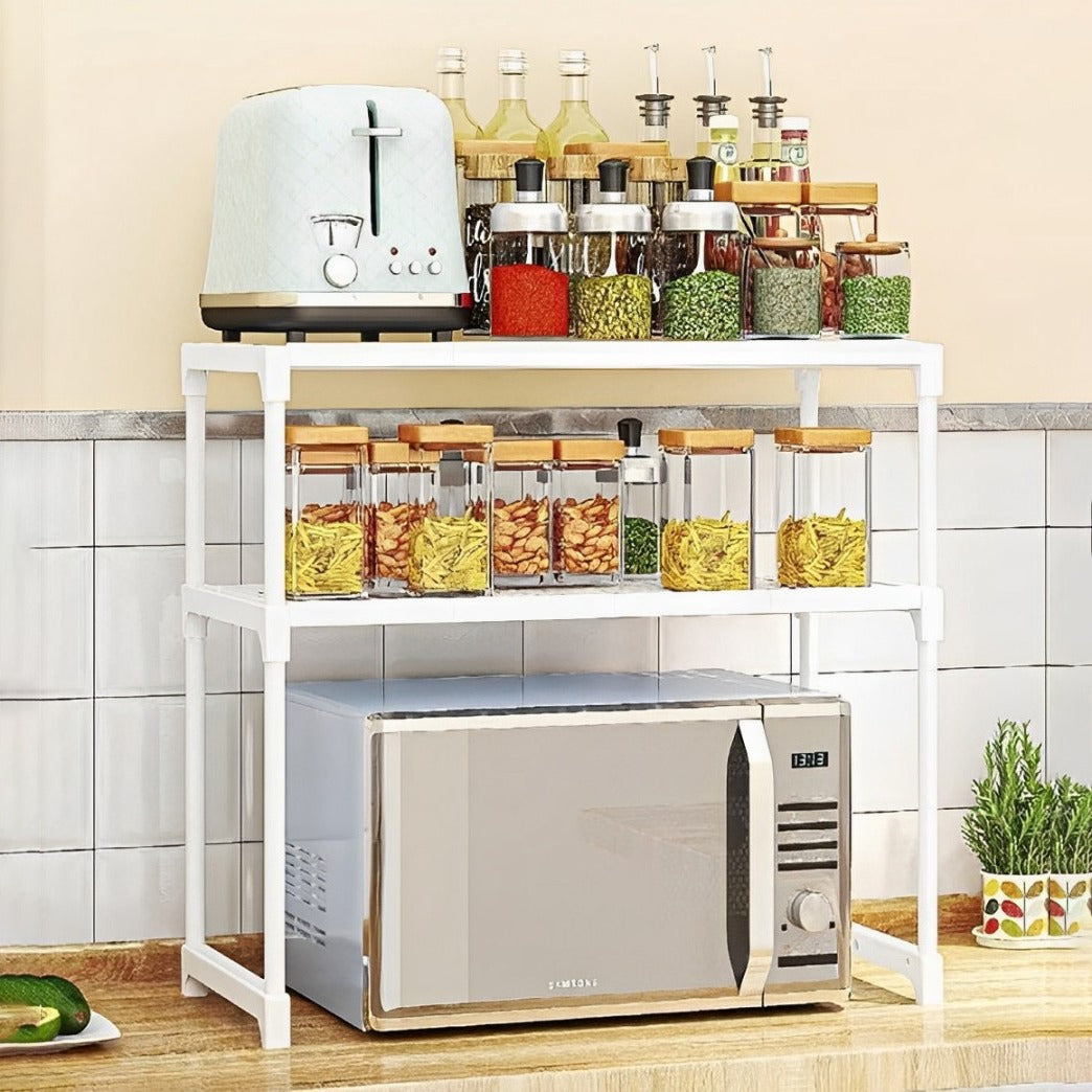 White double-layer rack organizing jars, bottles, and a microwave on a countertop