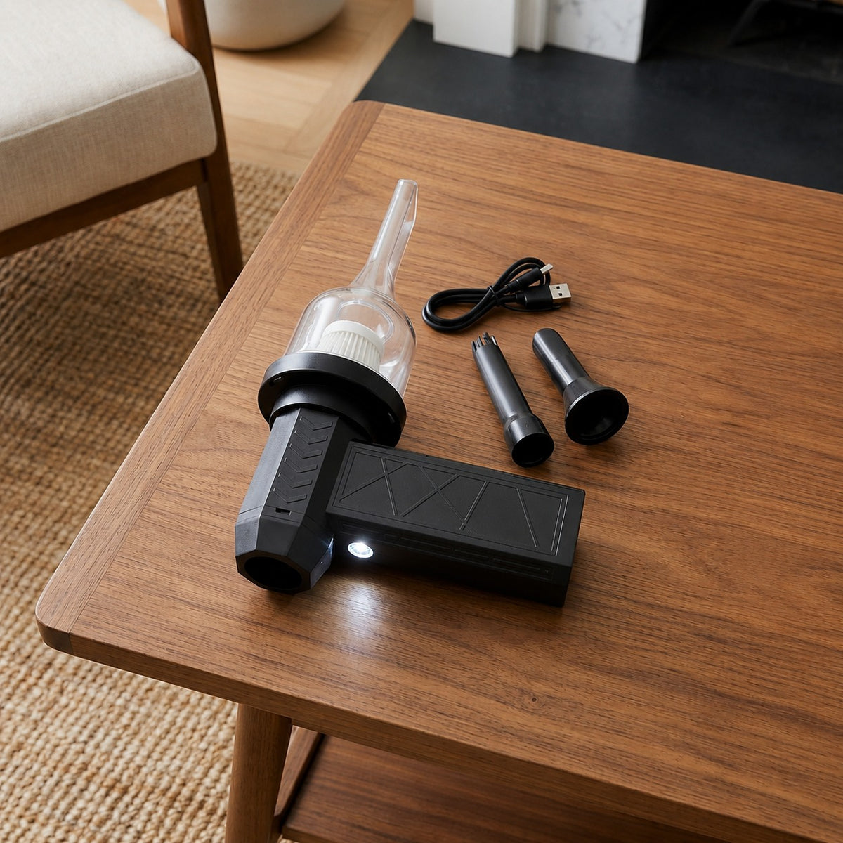 Black handheld air duster with attachments on a wooden table