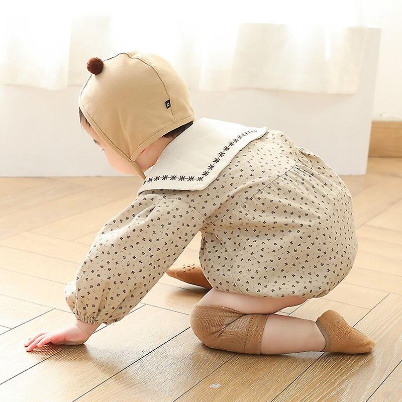 Happy baby crawling by wearing knee pads for safety.