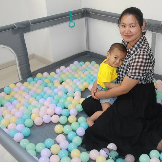 A Baby and Mom Inside a Baby Playpen..