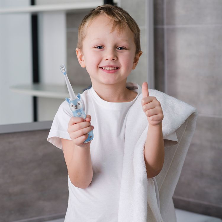 Smiling young boy holding a blue kids electric toothbrush, promoting fun and effective oral hygiene.