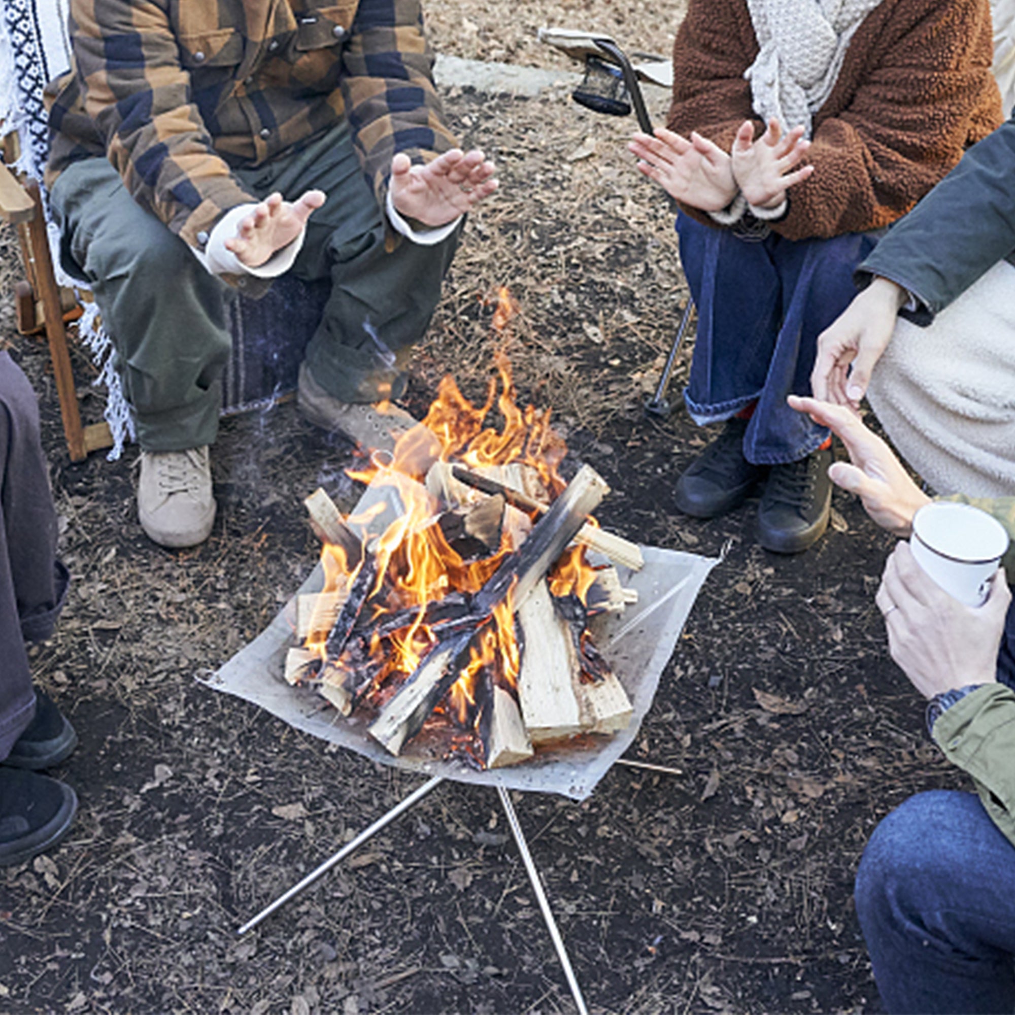 A Group of People Camping Around Stainless Steel Fire Pit.